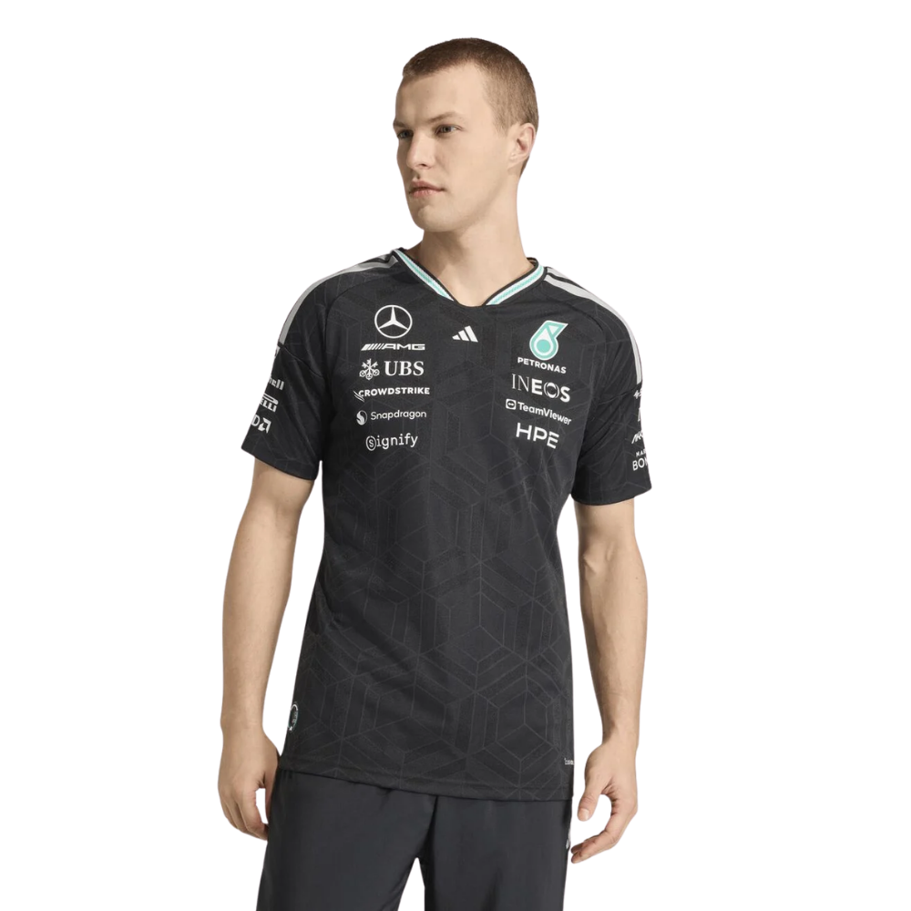 Man wearing a black sports jersey with various sponsor logos on a white background