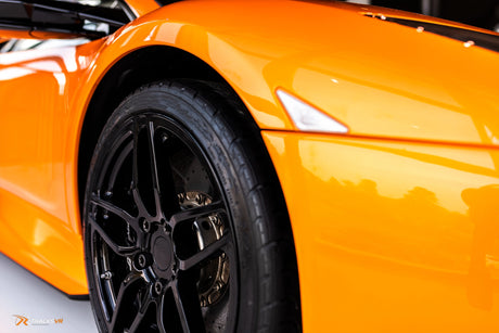 Close up of yellow McLaren with black rims 