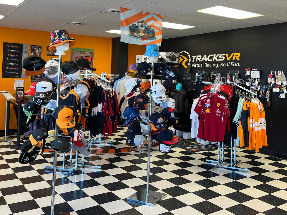 Store interior with clothing racks and 'TracksVR' branding on a black wall.